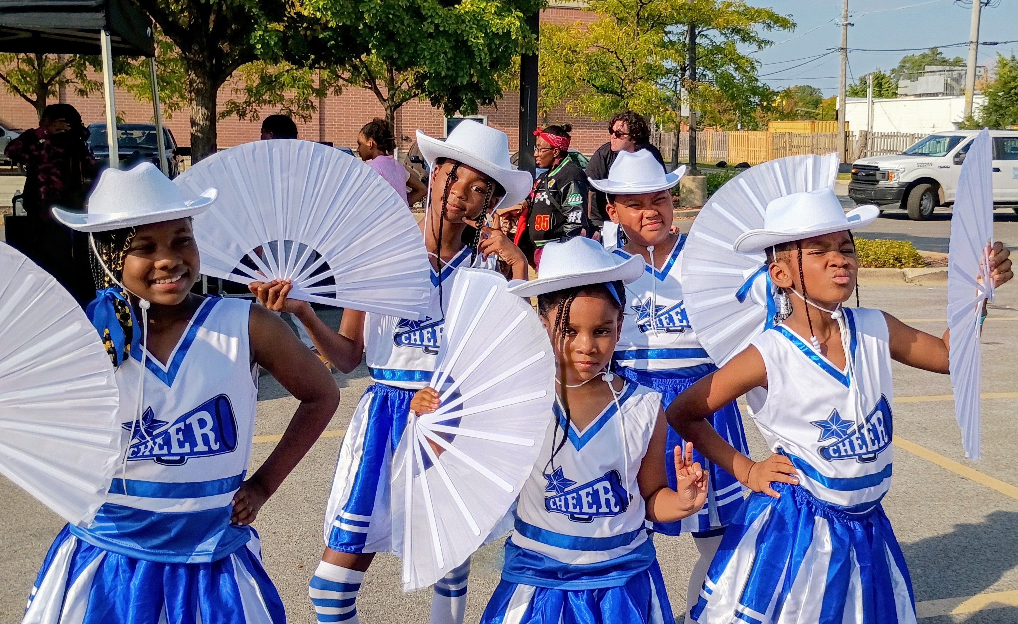 Reign Dancers in blue and white uniforms performing at a community event